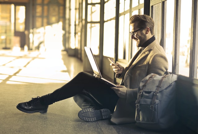 image of man laughing while looking at phone